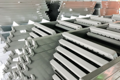 Powder coating line. Metal panels are suspended on an overhead conveyor line. Painting products in an electrostatic field.